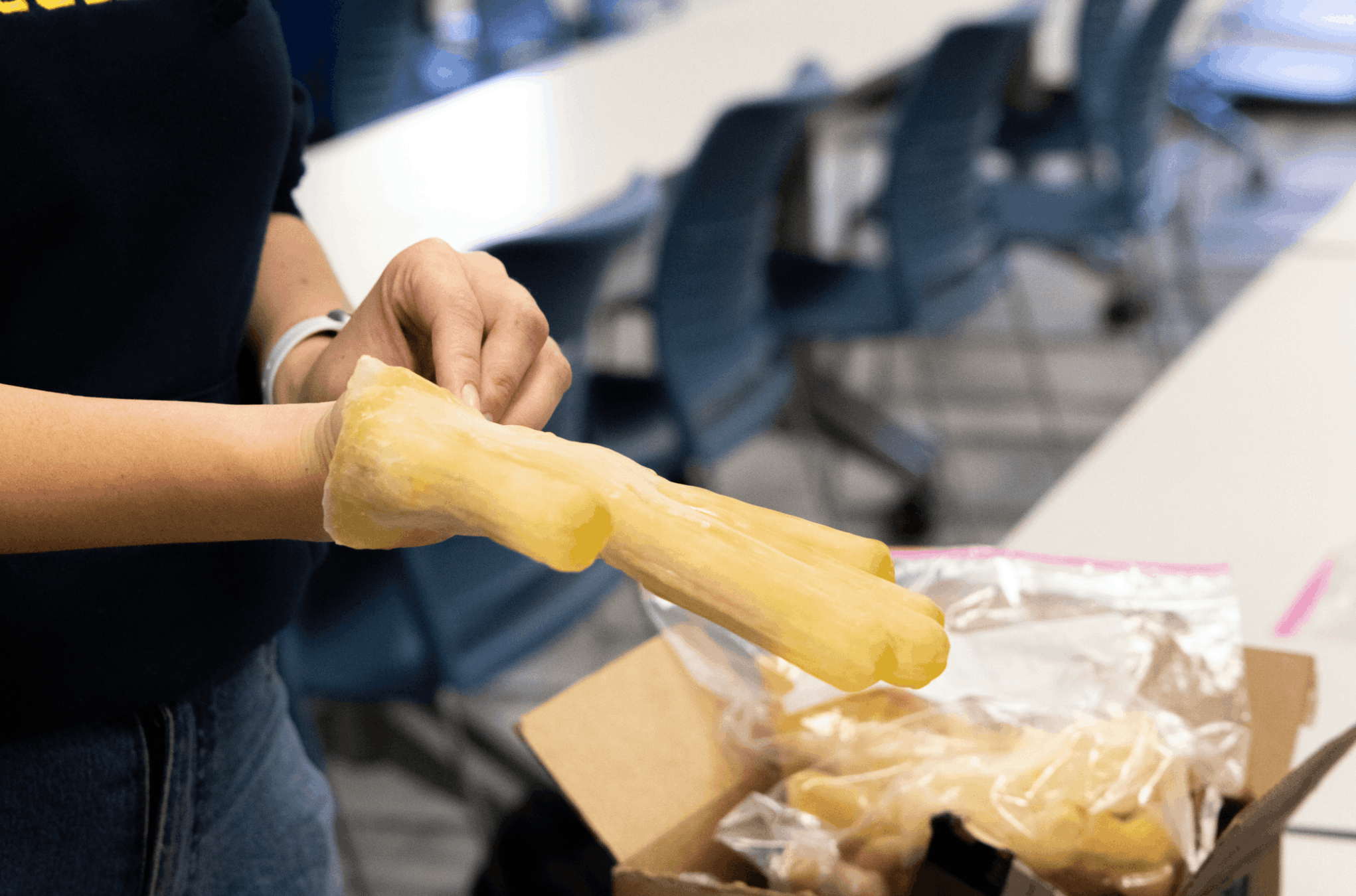 Person putting on a thick yellow glove