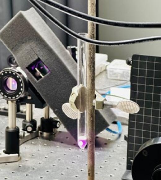 laser pointed at silica sand in a clear tube
