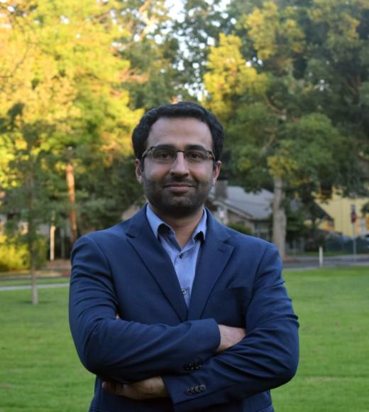 Amir Saeidi outside near green grass and trees